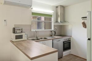 a small kitchen with a sink and a microwave at Nathan's Place in Whitfield