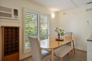a dining room with a table and chairs and a window at Nathan's Place in Whitfield +10 photos
