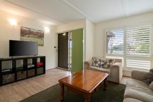 a living room with a couch and a tv at Nathan's Place in Whitfield
