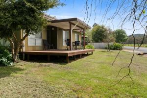 a house with a porch with a table and chairs on it at Nathan's Place in Whitfield