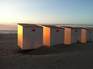 a row of beach huts on the beach at sunset at 6de Hemel - 6ème Ciel - 6th Heaven in Nieuwpoort