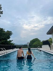 a man and woman standing in a swimming pool at Cloud & Rey condo rentals in Roxas City