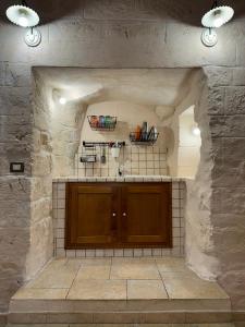 a kitchen with a counter and a stone wall at More Apartments il castello in Bari
