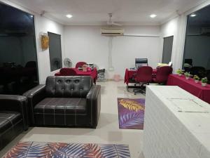 a living room with a leather couch and red tables at Kurau Stone Chalet in Taiping