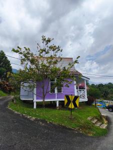 a purple house sitting on the side of a road at Kurau Stone Chalet in Taiping +3 photos