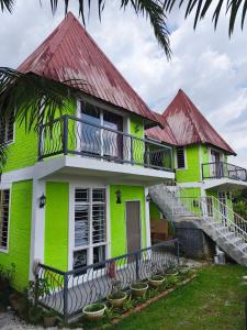 a green house with a red roof at Kurau Stone Chalet in Taiping
