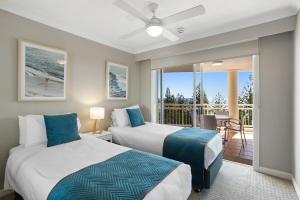 two beds in a room with a balcony at ULTIQA Burleigh Mediterranean Resort in Gold Coast +89 photos
