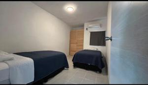 a bedroom with two beds and a door with a window at Departamento MAR in Coatzacoalcos