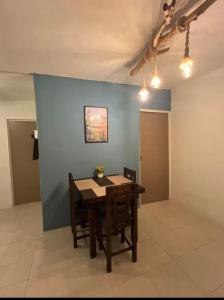 a dining room with a table and a blue wall at Departamento MAR in Coatzacoalcos