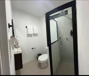 a bathroom with a toilet and a glass shower at Departamento MAR in Coatzacoalcos