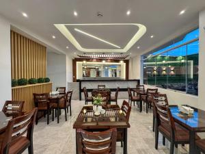 a restaurant with wooden tables and chairs and a large window at Hotel Yanahuara Suite in Arequipa