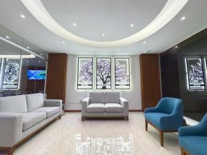 a living room with couches and chairs and windows at Hotel Yanahuara Suite in Arequipa