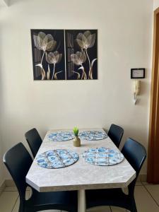 a table with four chairs with plates on it at Apartamento 02 QUARTOS, confortável no coração da Pampulha in Belo Horizonte +8 photos