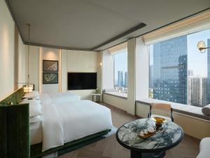 a bedroom with a white bed and a large window at Fairmont Xiamen in Xiamen