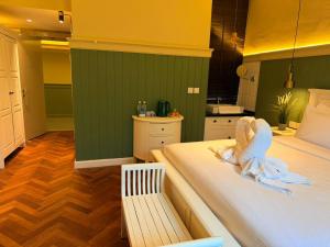 a room with two beds with a bench and a kitchen at The Chambers Georgetown in George Town +6 photos