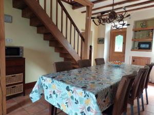 a dining room with a table with chairs and a staircase at Holiday Home in Limoges with Saltwater Pool in Châteauneuf-la-Forêt