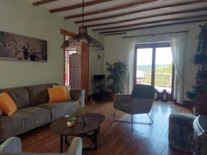 a living room with a couch and a table at Holiday Home in Limoges with Saltwater Pool in Châteauneuf-la-Forêt