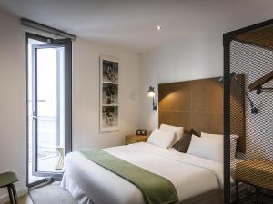 a hotel room with a large bed and a window at Aparthotel Adagio London Brentford in Brentford +51 photos