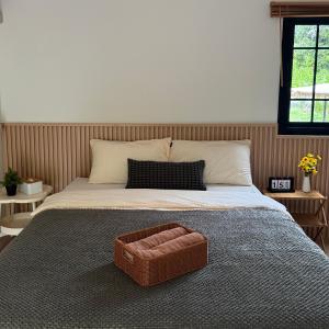 a bed with a basket on top of it at กางเขา แคมป์ปิ้ง in Ban Bung Mai