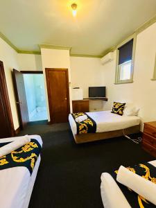 a hotel room with two beds and a television at Golden Age Hotel in Omeo +18 photos
