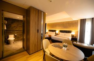 a hotel room with a table and a bedroom at Vibe Hotel Alabang in Manila