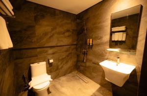 a bathroom with a toilet and a sink at Vibe Hotel Alabang in Manila +34 photos