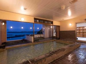 a swimming pool with a view of the ocean at Hamabenoyado Kameya in Toba