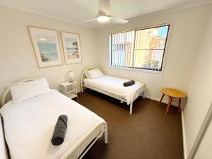 a bedroom with two beds and a window at Jubilee Apartment 06 in South West Rocks +15 photos