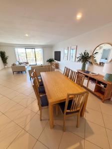 a living room with a wooden table and chairs at Jubilee Apartment 06 in South West Rocks