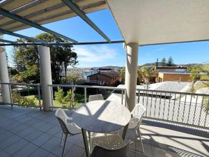 a patio with a table and chairs on a balcony at Jubilee Apartment 06 in South West Rocks