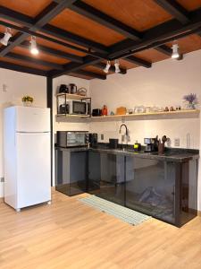 a kitchen with a white refrigerator and a counter at Villa Iñaru hospedaria in Aquidauana