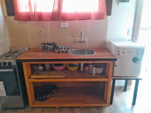 a small kitchen with a sink and a stove at Mi Refugio APART in El Chalten +21 photos
