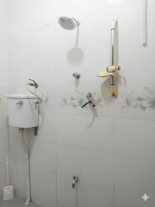 a white bathroom with a shower and a sink at D'Rembulan Homestay in Ranau +9 photos