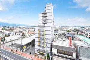 伊势原市伊势原市精选酒店的一座高大的白色建筑,靠近城市