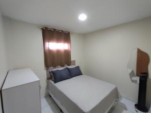 a small bedroom with a bed with a blue pillow at Excelente Apartamento in Buíque