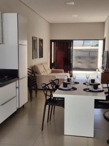 a kitchen and living room with a table and chairs at Casa Completa e Funcional in Sinop
