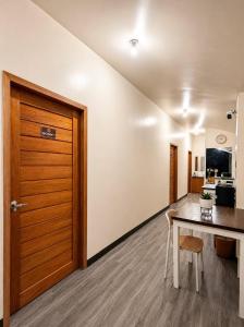 a room with a table and a wooden door at Bayay Isla Inn in General Luna