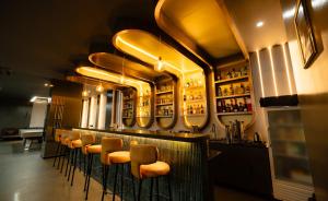 a bar with a row of chairs and mirrors at Vibe Hotel Alabang in Manila