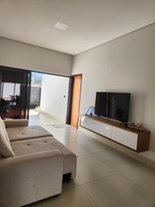 a living room with a couch and a flat screen tv at Casa Completa e Funcional in Sinop