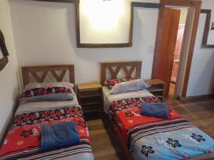 two beds in a room with a mirror at Mi Refugio APART in El Chalten