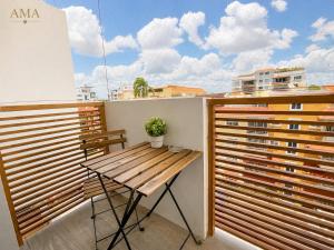 a balcony with a wooden table and a potted plant at Comfortable Central Apartment in Santo Domingo