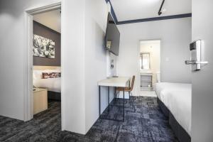 a hotel room with two beds and a desk with a bedroom at Nightcap at Wanneroo Tavern in Wanneru +57 photos