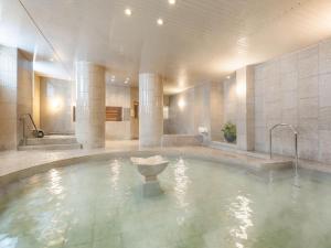 a large swimming pool with a fountain in a building at HOTEL MYSTAYS PREMIER Sapporo Park in Sapporo