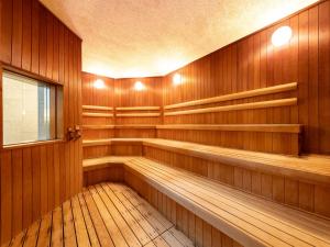 a sauna with wooden walls and benches and a window at HOTEL MYSTAYS PREMIER Sapporo Park in Sapporo