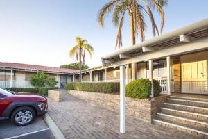 a red car parked in front of a building at Nightcap at Wanneroo Tavern in Wanneru