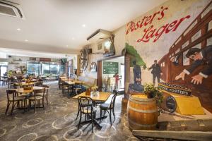 a restaurant with tables and chairs and a painting on the wall at Nightcap at Wanneroo Tavern in Wanneru