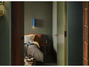 a bedroom with a bed and a blue window at Hyde Melbourne Place in Melbourne
