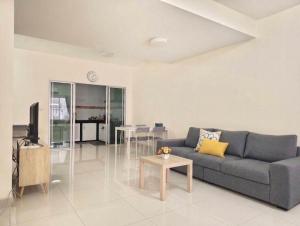 a living room with a couch and a table at Impact MT House in Ban Bang Phang