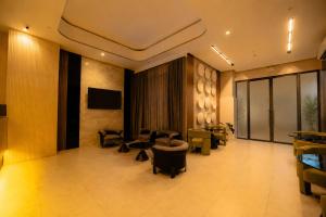 a lobby with couches and chairs and a television at Vibe Hotel Alabang in Manila