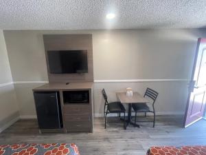 a dining room with a table and a flat screen tv at SimpleStay Suites - Downtown San Bernardino in San Bernardino